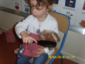 Maintenant, il faut coiffer la poupée à l'aide d'une brosse à cheveux